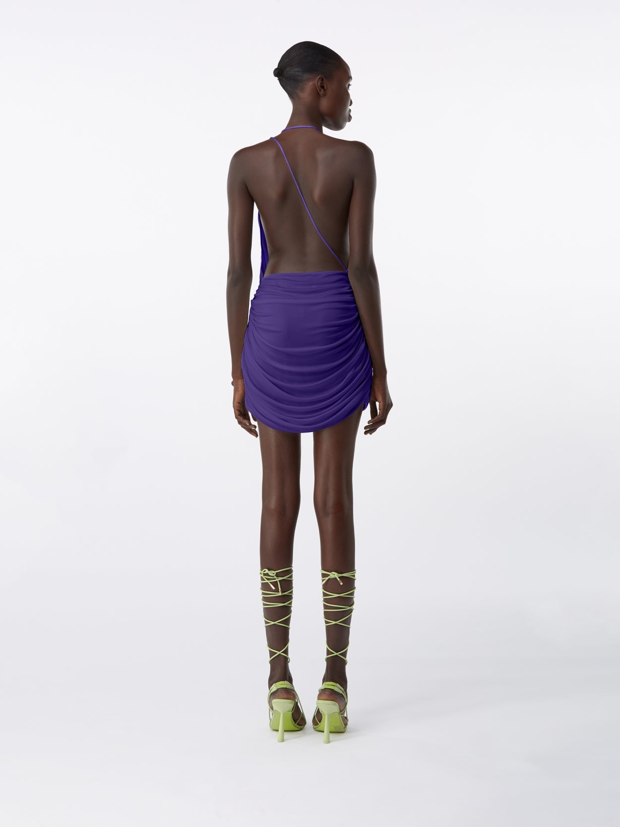 model wearing purple halter neck mini dress with  open back